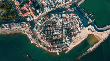 Molfetta rıhtımından ve eski kasabadan gelen güzel panoramik hava manzaralı fotoğraf. Gemileri ve yatları olan liman, Molfetta 'nın güneş doğarken yeni şehrini kapsıyor.)