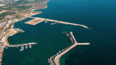 Molfetta rıhtımından ve eski kasabadan gelen güzel panoramik hava manzaralı fotoğraf. Gemileri ve yatları olan liman, Molfetta 'nın güneş doğarken yeni şehrini kapsıyor.)
