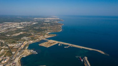 Molfetta rıhtımından ve eski kasabadan gelen güzel panoramik hava manzaralı fotoğraf. Gemileri ve yatları olan liman, Molfetta 'nın güneş doğarken yeni şehrini kapsıyor.)