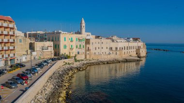 Molfetta rıhtımından ve eski kasabadan gelen güzel panoramik hava manzaralı fotoğraf. Gemileri ve yatları olan liman, Molfetta 'nın güneş doğarken yeni şehrini kapsıyor.)