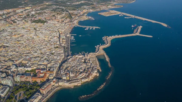 Molfetta rıhtımından ve eski kasabadan gelen güzel panoramik hava manzaralı fotoğraf. Gemileri ve yatları olan liman, Molfetta 'nın güneş doğarken yeni şehrini kapsıyor.)