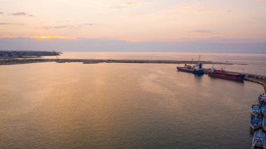 Molfetta limanındaki deniz fenerinde uçan İHA 'dan güzel panoramik hava manzaralı fotoğraf. Günbatımında gemiler, liman, yat kumu ve Molfetta şehriyle arka planda.)