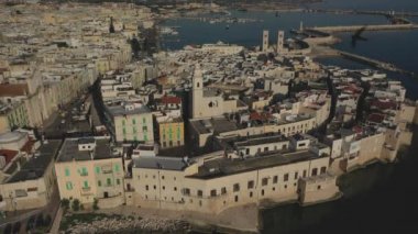 Molfetta rıhtımında ve büyük bir yükseklikten eski kentte uçan İHA 'nın güzel panoramik hava 4K videosu. Gemileri ve yatları olan liman, Molfetta' nın güneşte yeni şehrini kapsıyor.)
