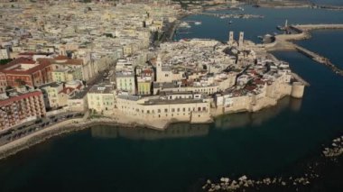 Molfetta rıhtımında ve büyük bir yükseklikten eski kentte uçan İHA 'nın güzel panoramik hava 4K videosu. Gemileri ve yatları olan liman, Molfetta' nın güneşte yeni şehrini kapsıyor.)