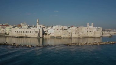 Molfetta rıhtımında ve büyük bir yükseklikten eski kentte uçan İHA 'nın güzel panoramik hava 4K videosu. Gemileri ve yatları olan liman, Molfetta' nın güneşte yeni şehrini kapsıyor.)
