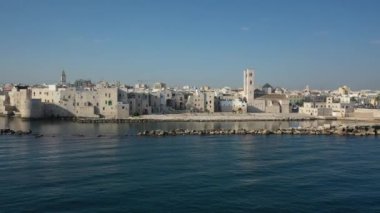 Molfetta rıhtımında ve büyük bir yükseklikten eski kentte uçan İHA 'nın güzel panoramik hava 4K videosu. Gemileri ve yatları olan liman, Molfetta' nın güneşte yeni şehrini kapsıyor.)
