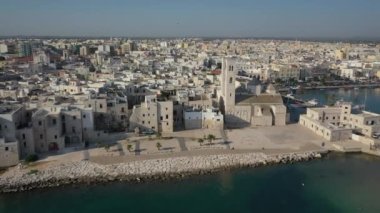 Molfetta rıhtımında ve büyük bir yükseklikten eski kentte uçan İHA 'nın güzel panoramik hava 4K videosu. Gemileri ve yatları olan liman, Molfetta' nın güneşte yeni şehrini kapsıyor.)
