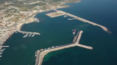 Molfetta rıhtımında ve büyük bir yükseklikten eski kentte uçan İHA 'nın güzel panoramik hava 4K videosu. Gemileri ve yatları olan liman, Molfetta' nın güneşte yeni şehrini kapsıyor.)