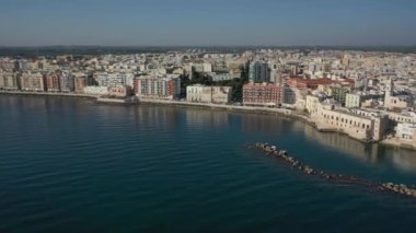 Molfetta rıhtımında ve büyük bir yükseklikten eski kentte uçan İHA 'nın güzel panoramik hava 4K videosu. Gemileri ve yatları olan liman, Molfetta' nın güneşte yeni şehrini kapsıyor.)