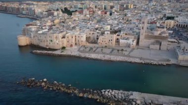 Uçan İHA 'dan Molfetta plajına ve Old Town ufuk çizgisine ve liman manzarasına güzel panoramik 4K video. Günbatımında güney İtalya 'da bir turizm beldesi. İtalya' nın Apulia kentinde Molfetta kenti (Serisi)