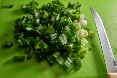 Kesme tahtasına yakın çekimde dilimlenmiş soğan bırakılmış.