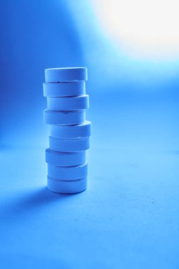 Mavi arka planda duran bir yığın tablet