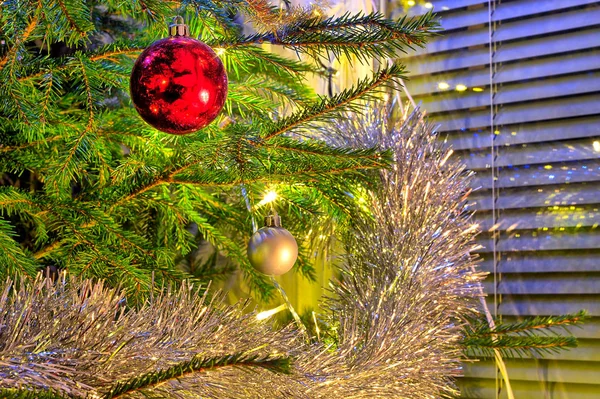 Rode Glanzende Kerstbal Kerstboom Omringd Door Groene Takken Gouden Glitter — Stockfoto