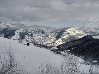 Güzel bir kış manzarası. Romanya, Trasilvania, Parva köyünde karla kaplı Karpat dağlarında Kabin.