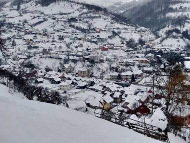Transilvanya Romanya parva köyünde dağ evleri ve ağaçlar ile kış sezonunda. Kış manzaraları