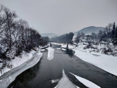 Kış mevsiminde kar ve buz ile donmuş nehir. Romanya, Transilvanya, Nasaud şehri. Kış manzarası