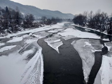 Kış mevsiminde kar ve buz ile donmuş nehir. Romanya, Transilvanya, Nasaud şehri. Kış manzarası