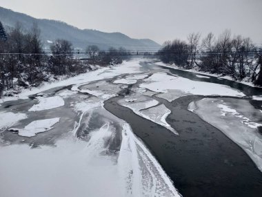 Kış mevsiminde kar ve buz ile donmuş nehir. Romanya, Transilvanya, Nasaud şehri. Kış manzarası