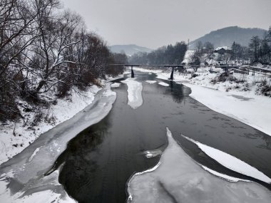 Kış mevsiminde kar ve buz ile donmuş nehir. Romanya, Transilvanya, Nasaud şehri. Kış manzarası