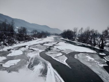 Kış mevsiminde kar ve buz ile donmuş nehir. Romanya, Transilvanya, Nasaud şehri. Kış manzarası