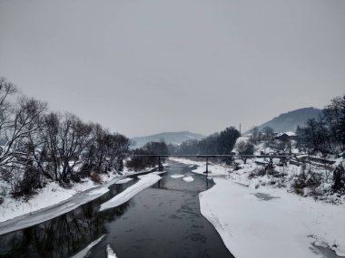 Kış mevsiminde kar ve buz ile donmuş nehir. Romanya, Transilvanya, Nasaud şehri. Kış manzarası