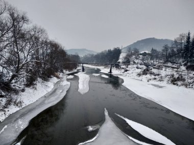 Kış mevsiminde kar ve buz ile donmuş nehir. Romanya, Transilvanya, Nasaud şehri. Kış manzarası