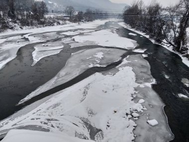 Kış mevsiminde kar ve buz ile donmuş nehir. Romanya, Transilvanya, Nasaud şehri. Kış manzarası