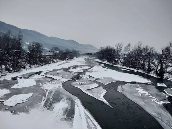 Kış mevsiminde kar ve buz ile donmuş nehir. Romanya, Transilvanya, Nasaud şehri. Kış manzarası