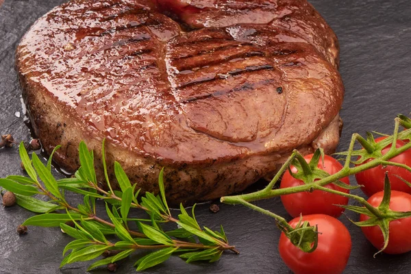 Gegrilltes Rindersteak Mit Kirschtomaten Und Gewürzen Auf Schwarzem Steinbrett — Stockfoto