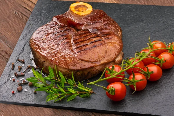 Gegrilltes Rindersteak Mit Kirschtomaten Und Gewürzen Auf Schwarzem Steinbrett — Stockfoto