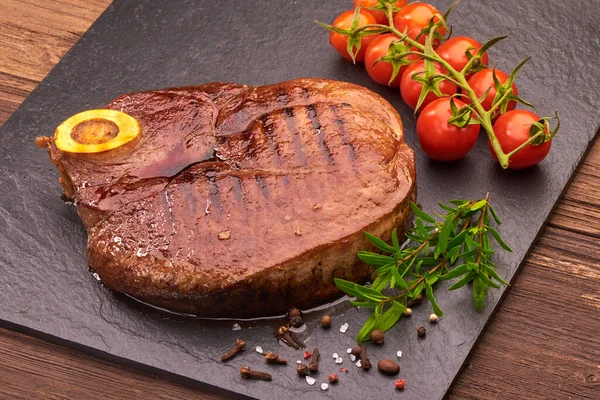 Gegrilde Biefstuk Met Kerstomaten Specerijen Zwarte Stenen Plank — Stockfoto