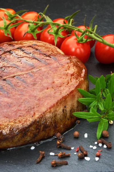 Gegrilltes Rindersteak Mit Kirschtomaten Und Gewürzen Auf Schwarzem Steinbrett — Stockfoto