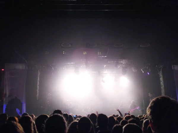 Las siluetas de los jóvenes ante la escena en el concierto. Grupo de rock. Multitud de personas en un concierto — Foto de Stock