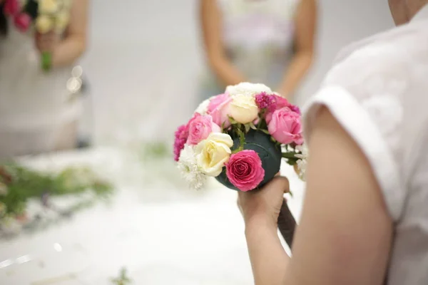 Femme crée un bouquet de mariée avec d'autres filles — Photo