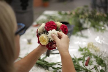 kız farklı çiçeklerden bir buket süsler