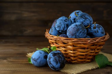 Tahta masada sepetin içinde tatlı erikler ve metin için fotokopi alanı. Seçici odak.