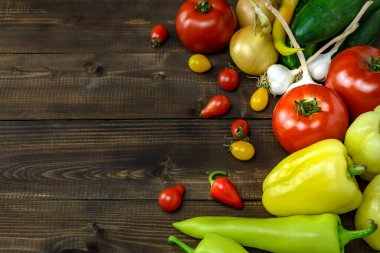 Tahta bir masanın üzerinde bir yığın taze sebze ve metin için kopyalama alanı var..