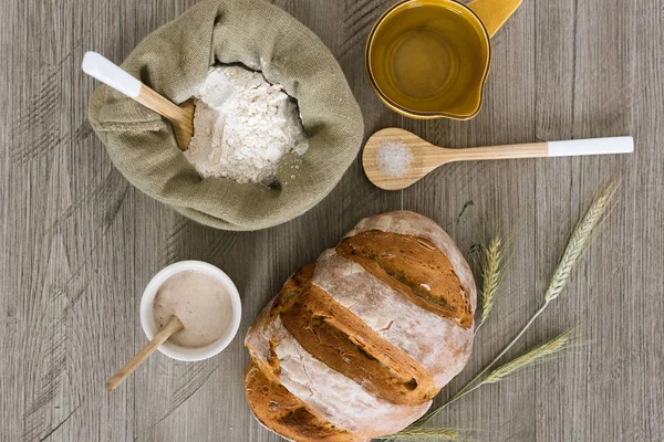 Çiçek, hamur mayası Başlatıcı, tuz, su ve kulakları buğday rustik bir tablo ile ev yapımı hamur mayası ekmek.