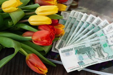 Bir buket çiçek bir dolarlık banknot Rublesi banknotların arka plan üzerinde sarılı. Mart 8. Uluslararası kadın