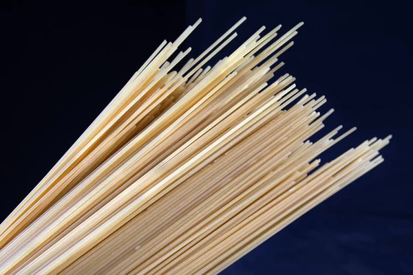 Siyah bir zemin üzerine sarı uzun spagetti. Sarı İtalyan makarna. Uzun spagetti. Pişmemiş spagetti bolognese. Pişmemiş spagetti. Gıda arka plan kavramı.