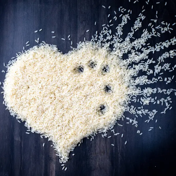 üstten görünüm kalp sembol siyah arka plan üzerine kaynatılmış pirinç 