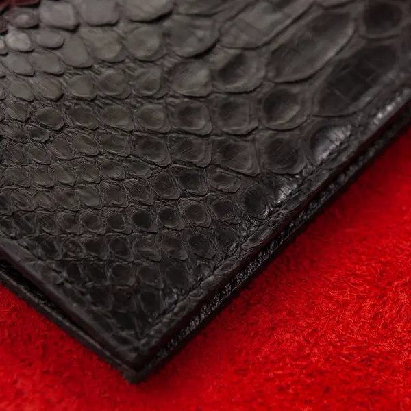 Egzotik ve lüks el yapımı deri cüzdan kümesi. Çok renkli. Deri el sanatları. Arka plan ile Plumeria bir taş döşeme üzerinde. Python piton yılan moda çanta, çanta, debriyaj. Python aksesuarları