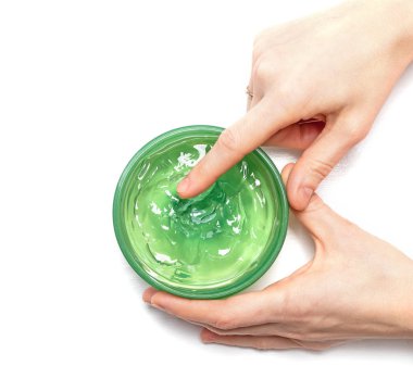 Aloe Vera jel beyaz arka planda bir kavanozdan scooping bir kadın el üzerinde, bakış üst. Aloe Vera güneş yanığı kabartma için doğal bir çare.