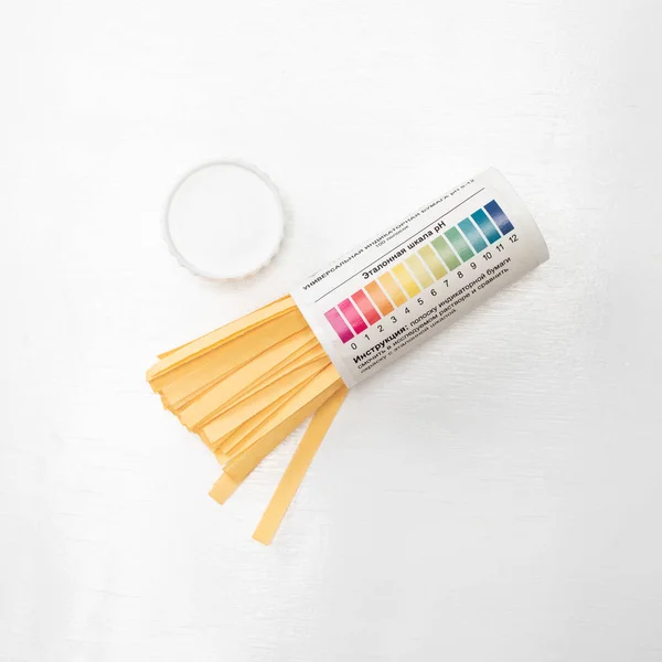 Pack of litmus test paper and color samples on white background. Universal indicator paper.Checking the ph.