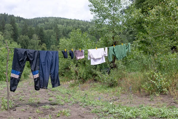 Rope with wet clothes in the open air. Tourist camp life.
