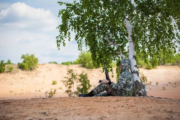 Man Camouflage Uniform Gun Sits Tree Desert — Stock Photo, Image