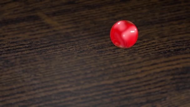 Una Bola Vidrio Rojo Rueda Sobre Superficie Madera Profundidad Campo — Vídeos de Stock