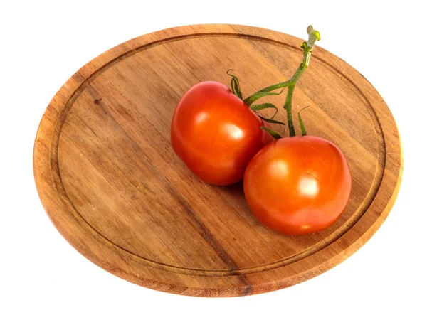 Dojrzałe czerwone pomidory na okrągłej drewnianej deski do krojenia. biały backgro — Zdjęcie stockowe