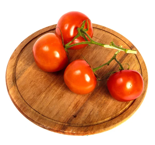 Rijpe rode tomaten op een ronde houten snijplank. witte blauw — Stockfoto