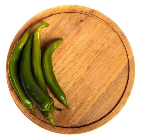 Chiles verdes en una tabla de cortar de madera. sobre un respaldo blanco — Foto de Stock